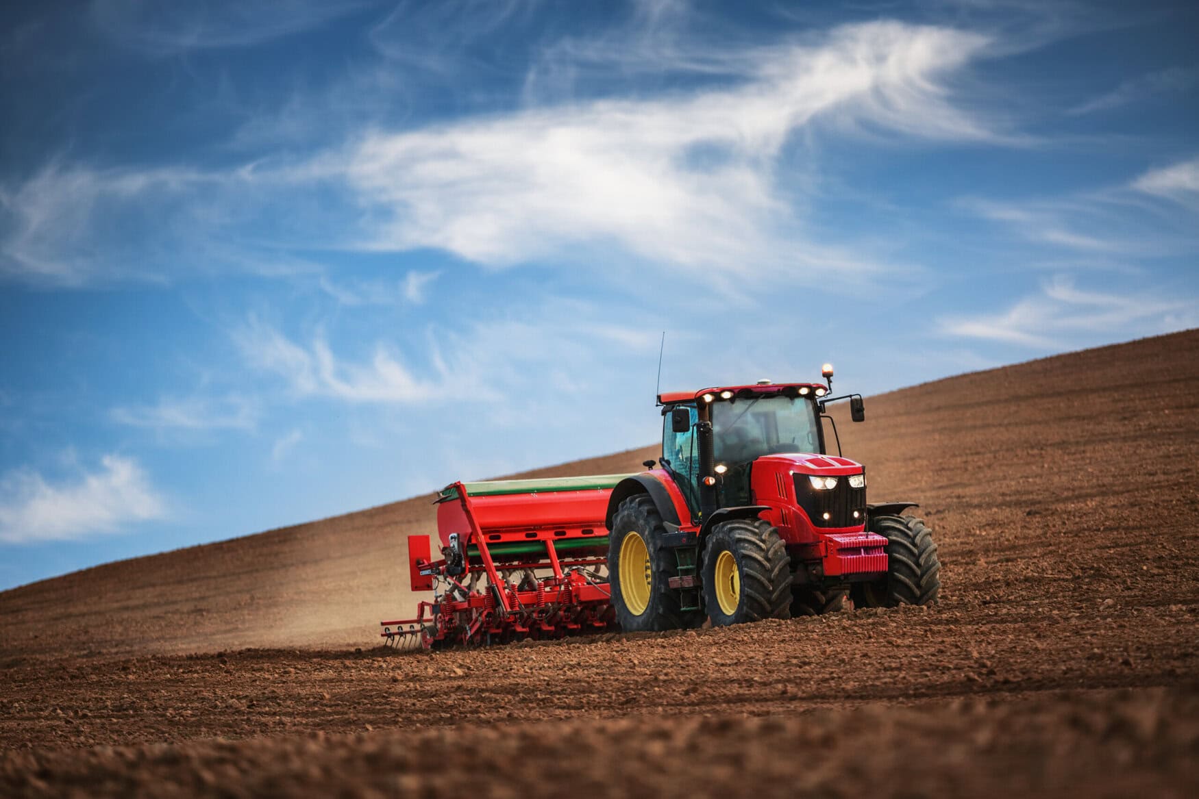 Farmer in tractor preparing farmland with seedbed for the next year